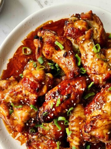 Close up of sticky soy wings on a white plate