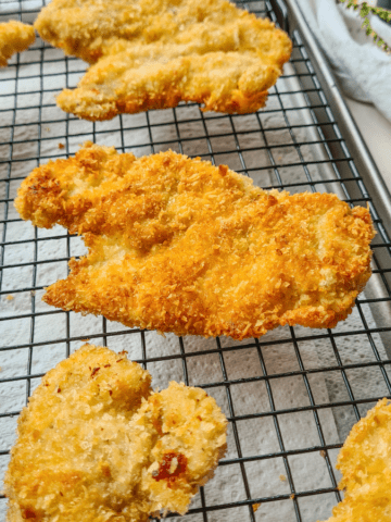 Crispy, golden panko chicken schnitzel resting on a cooling rack