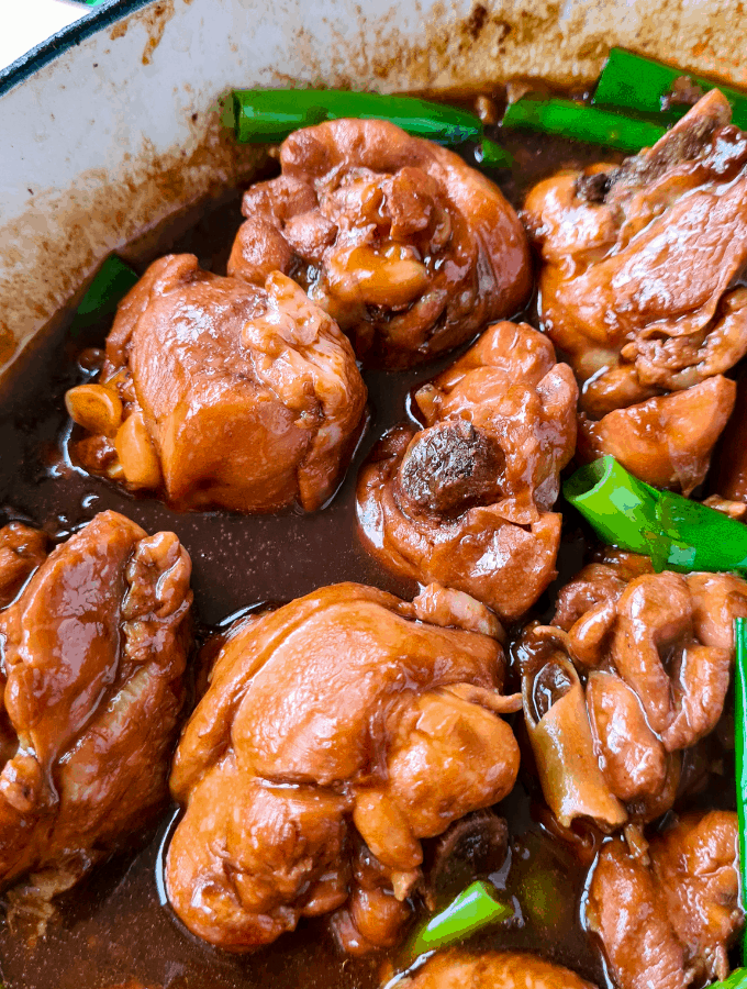 close up shot of coocked soy sauce chicken, drenched in tasty sauce and glossy in colour