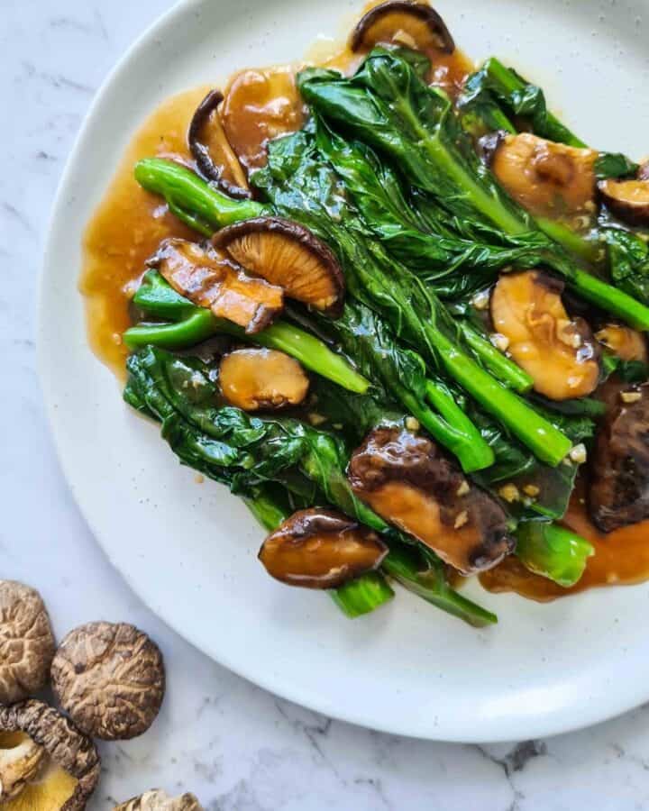 Close up of Chinese broccoli with shiitake mushrooms on top left corner