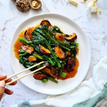 Plate of Chinese broccoli with mushrooms and sauce