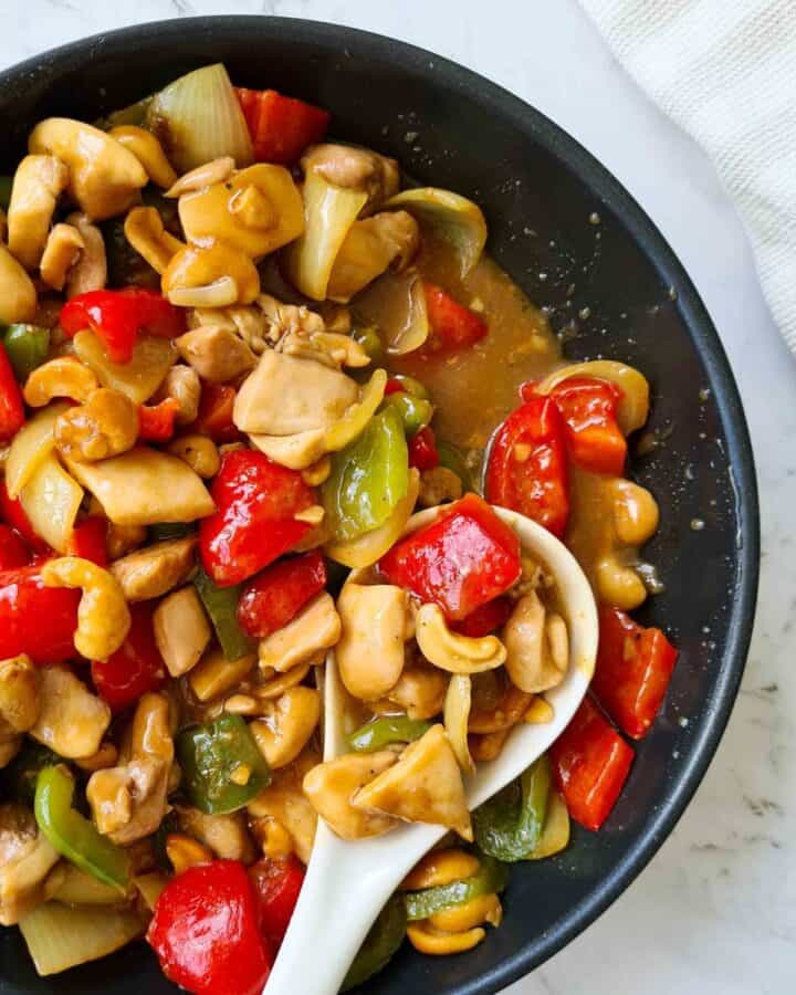 Close up, side profile of cashew chicken showing lots of sauces