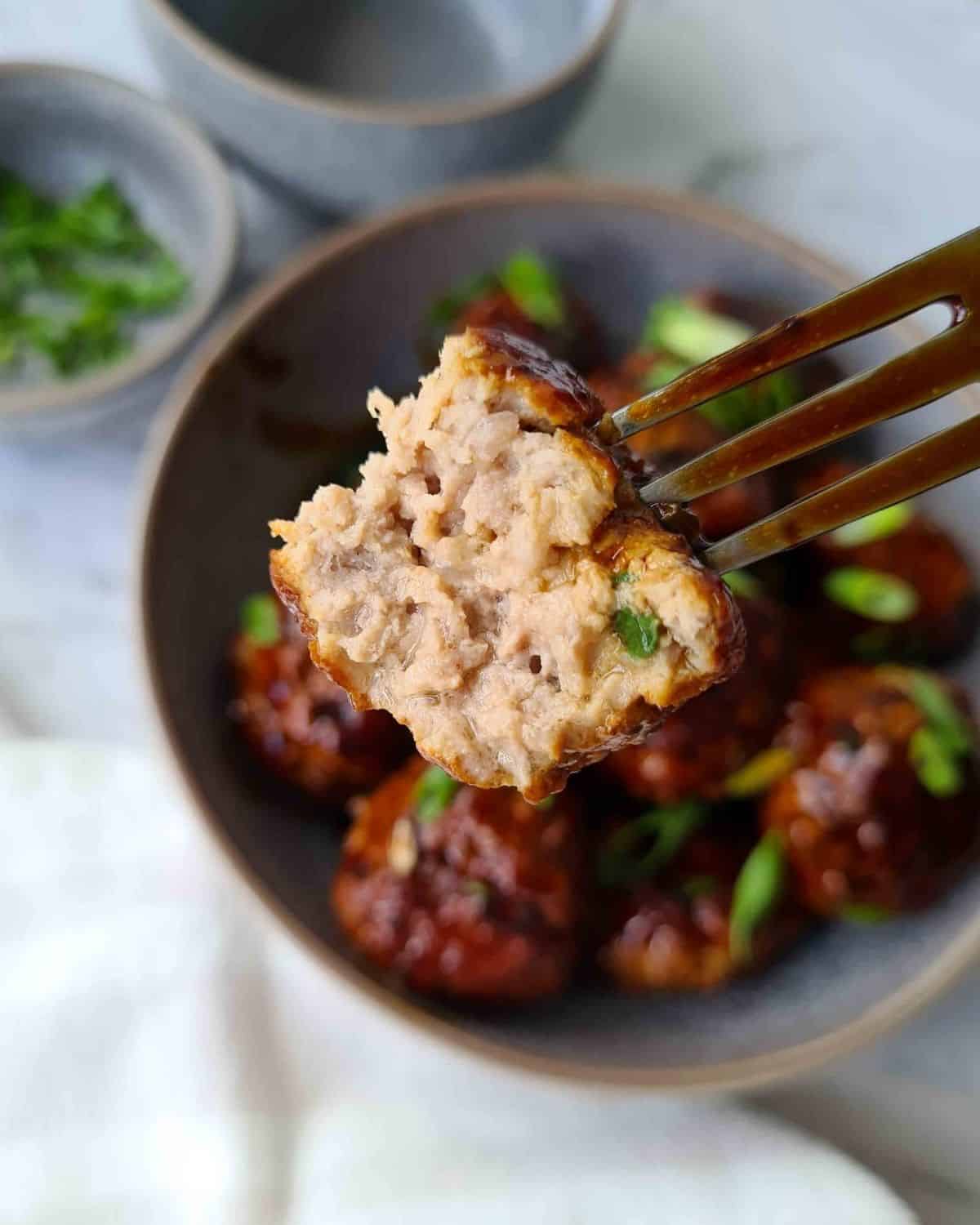 Close up of a bitten meatball, showing its juiciness