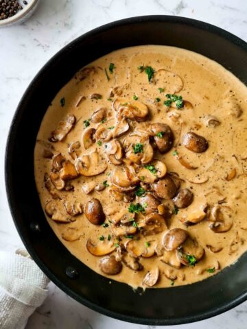 Creamy mushroom sauce in a black pan