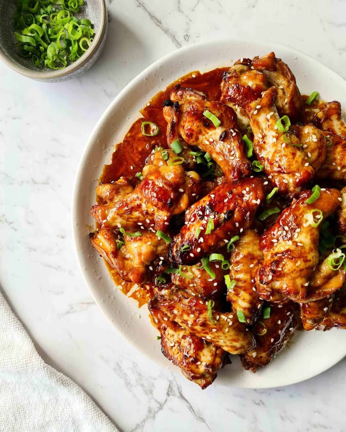 Sticky, saucy baked wings on a white plate
