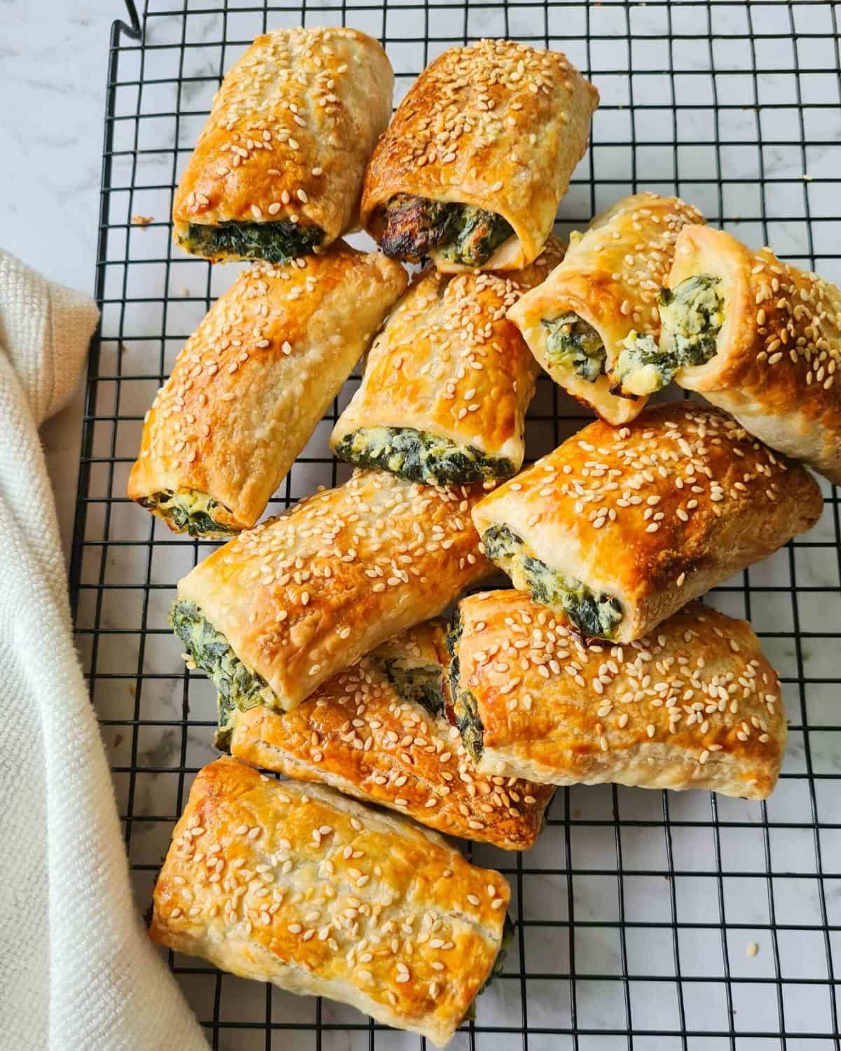 cooled spinach ricotta rolls stacked on a cooling rack