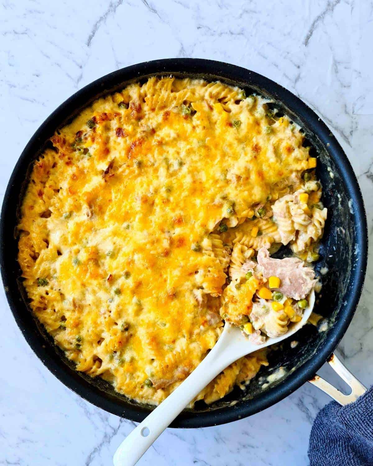 Freshly baked tuna mornay pasta bake with a portion spooned out