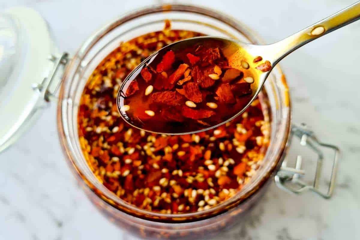 A spoonful of homemade chilli oil out of a jar