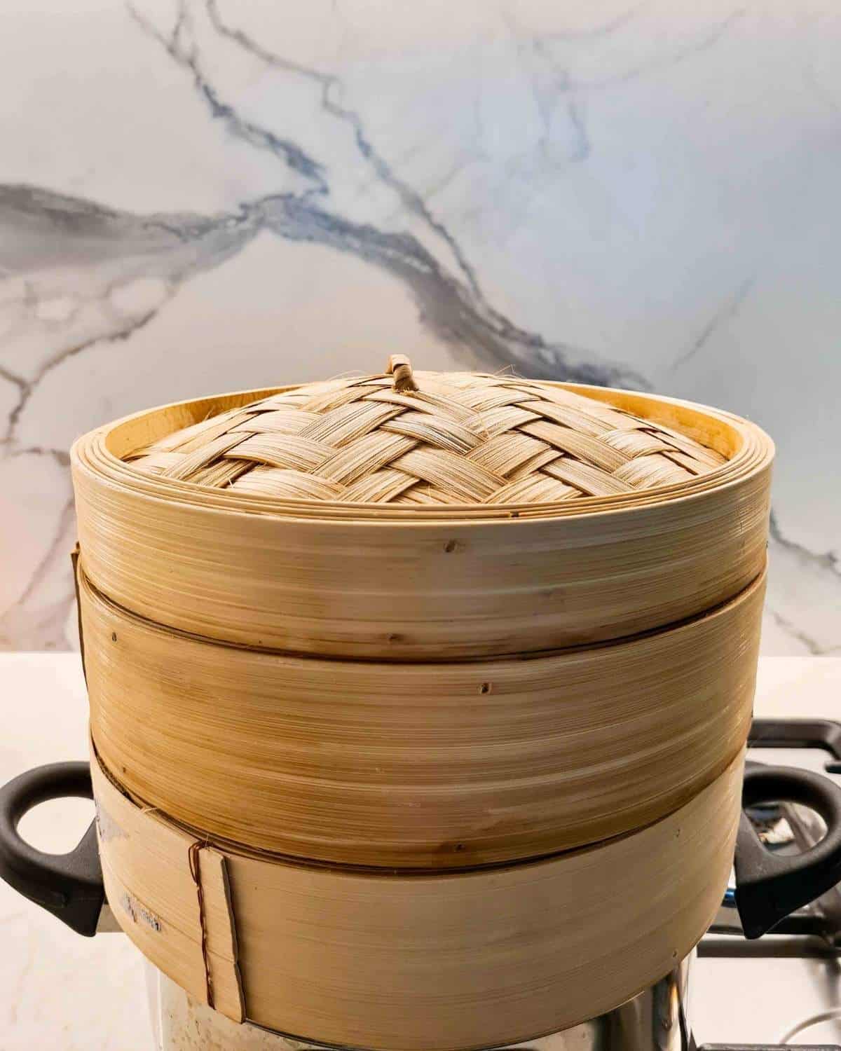 Dumplings being steamed inside bamboo steamer baskets