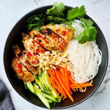 A bowl of vermicelli salad with sliced chicken