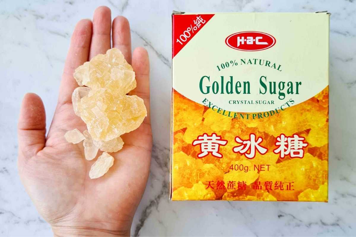 A box of Chinese crystal rock sugar with a palm full of sugar 