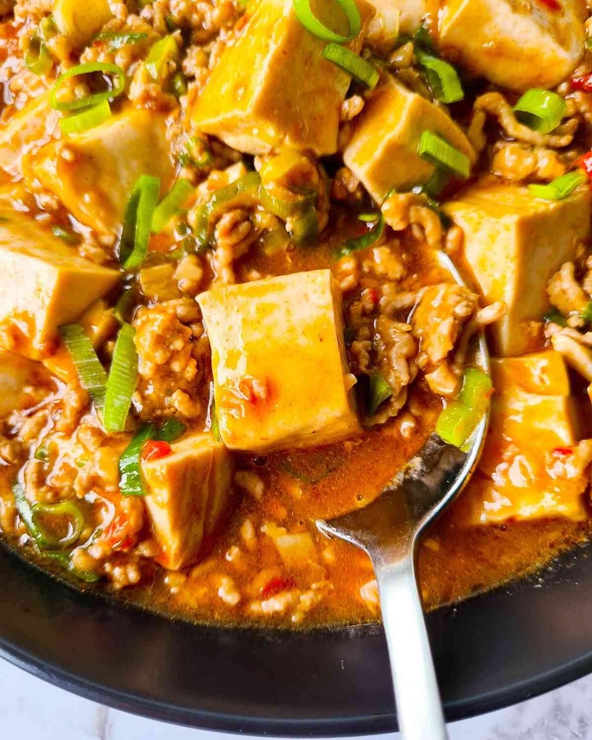Close up of a spoonful of tofu with pork mince