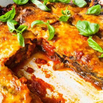 Side view of a tray of eggplant parmigiana with a slice taken out