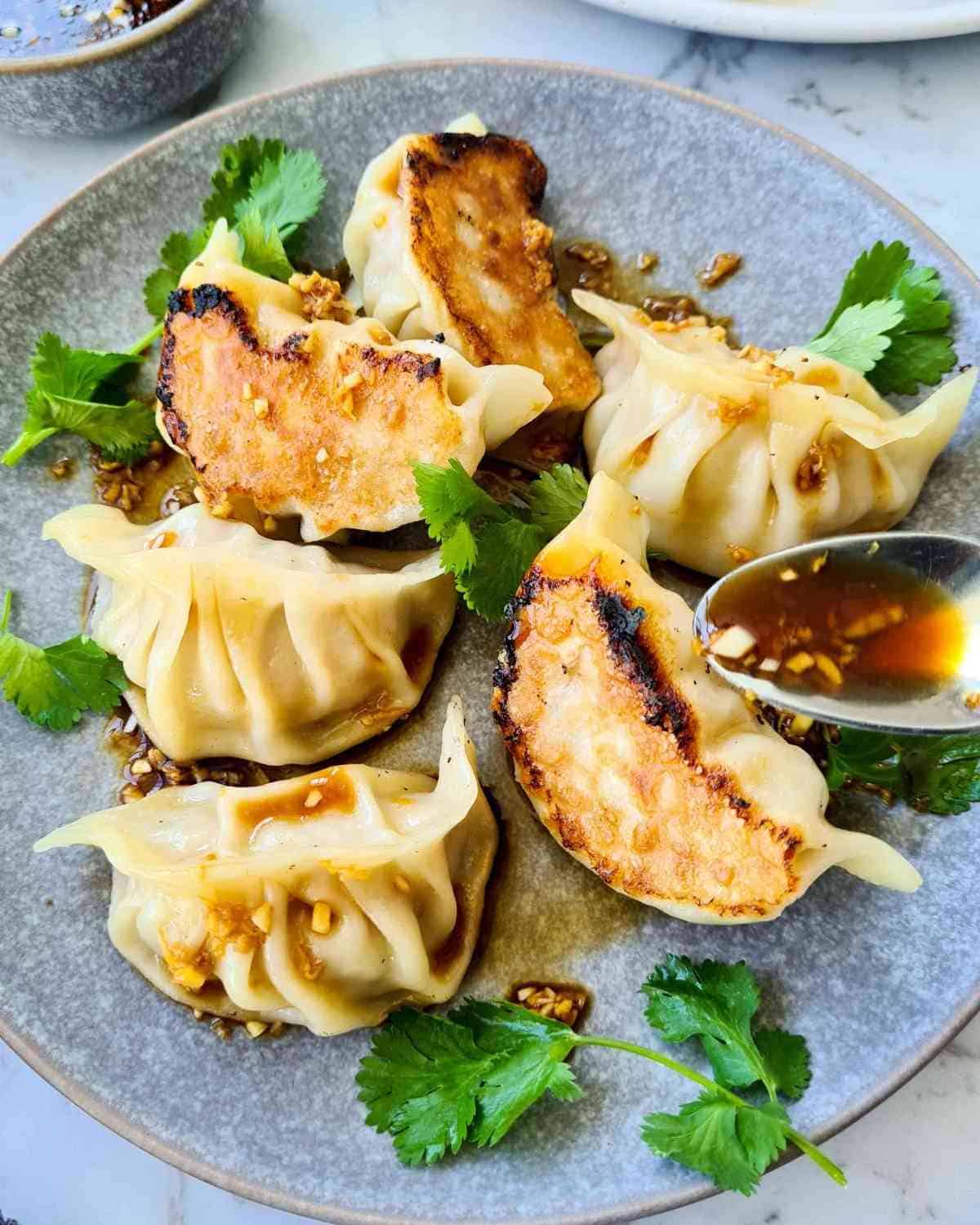 Close up of cooked dumplings in a grey plate