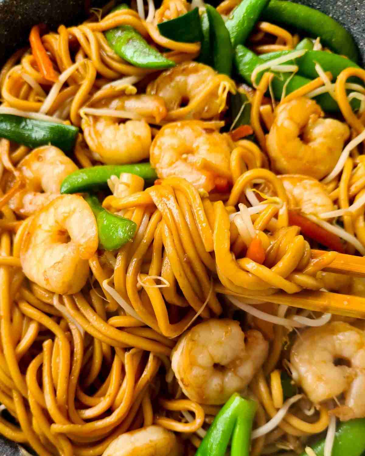Close up of thick noodles with vegetables and prawns