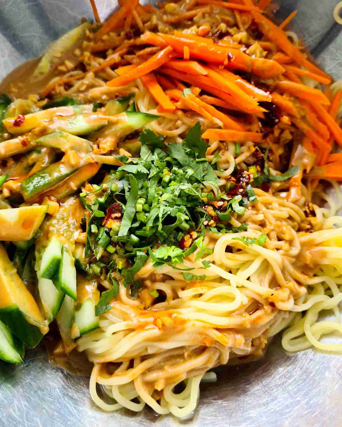 Close up of noodles salad with dressing before being mixed together