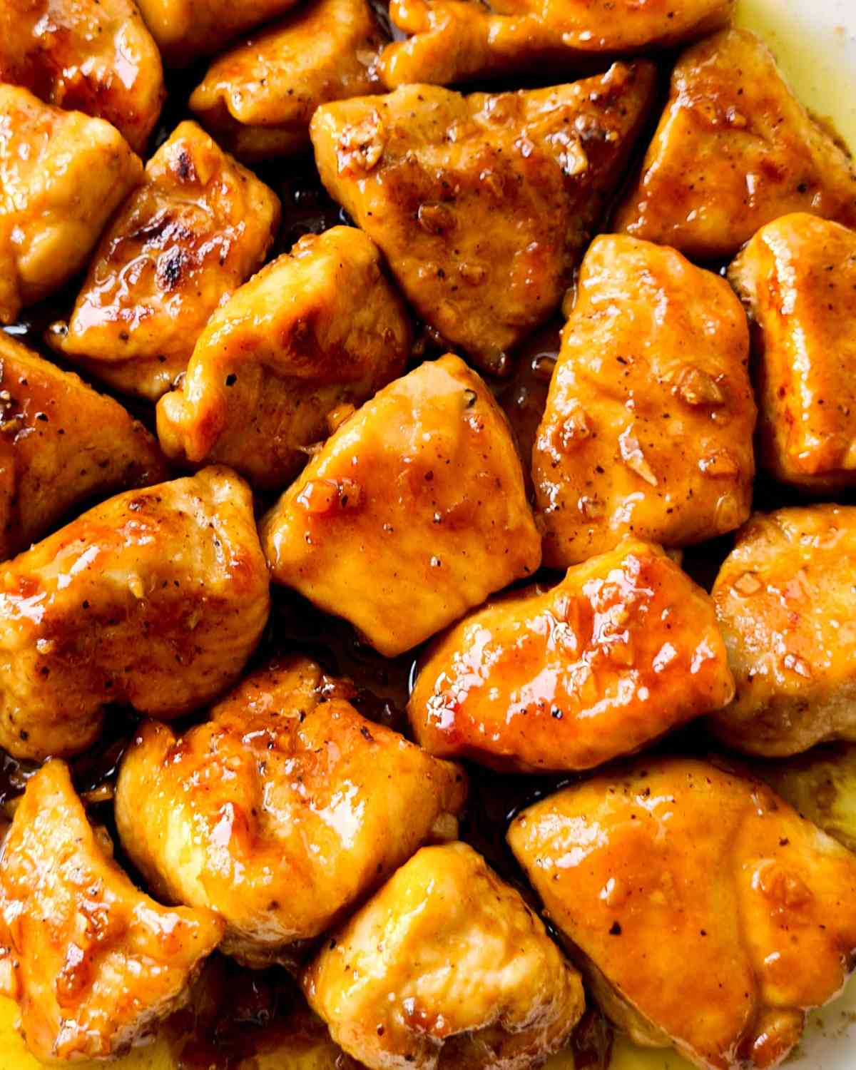 Close up of glossy glazed chicken bite sized pieces
