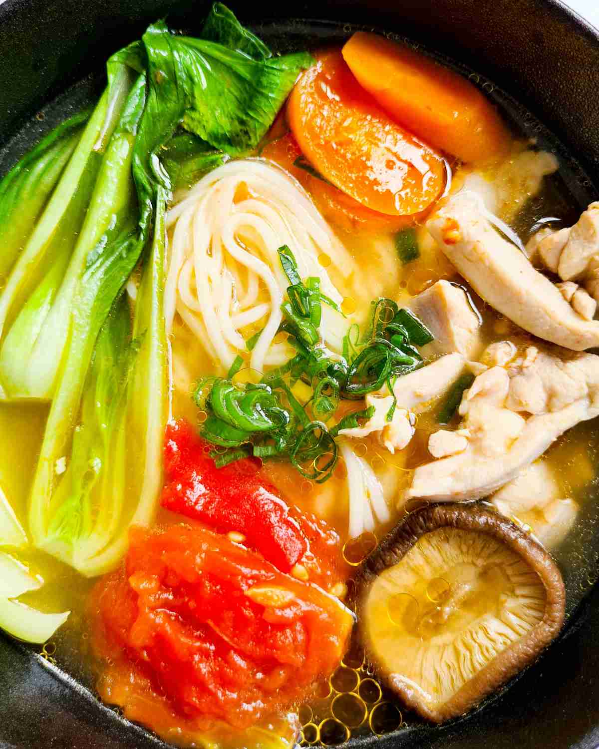 Close up of a bowl of noodle soup with vegetables
