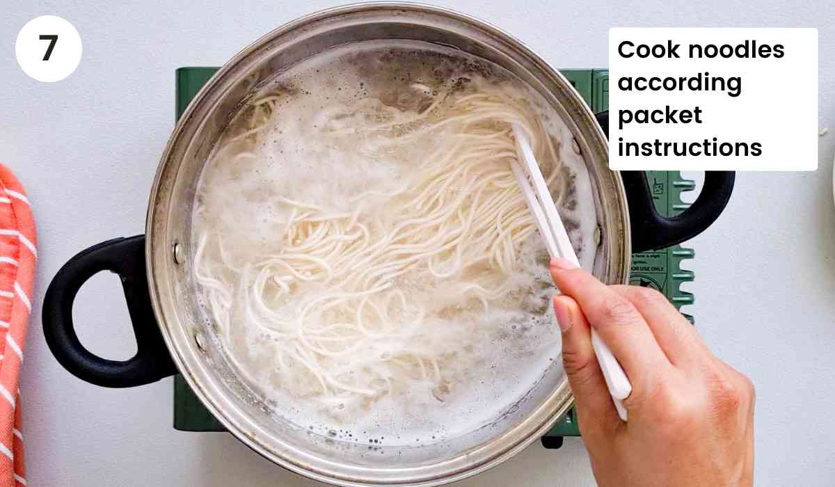 noodles being cooked in a pot of water with caption