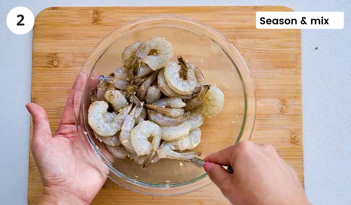 Shrimp (prawns) being mixed in seasoning with caption