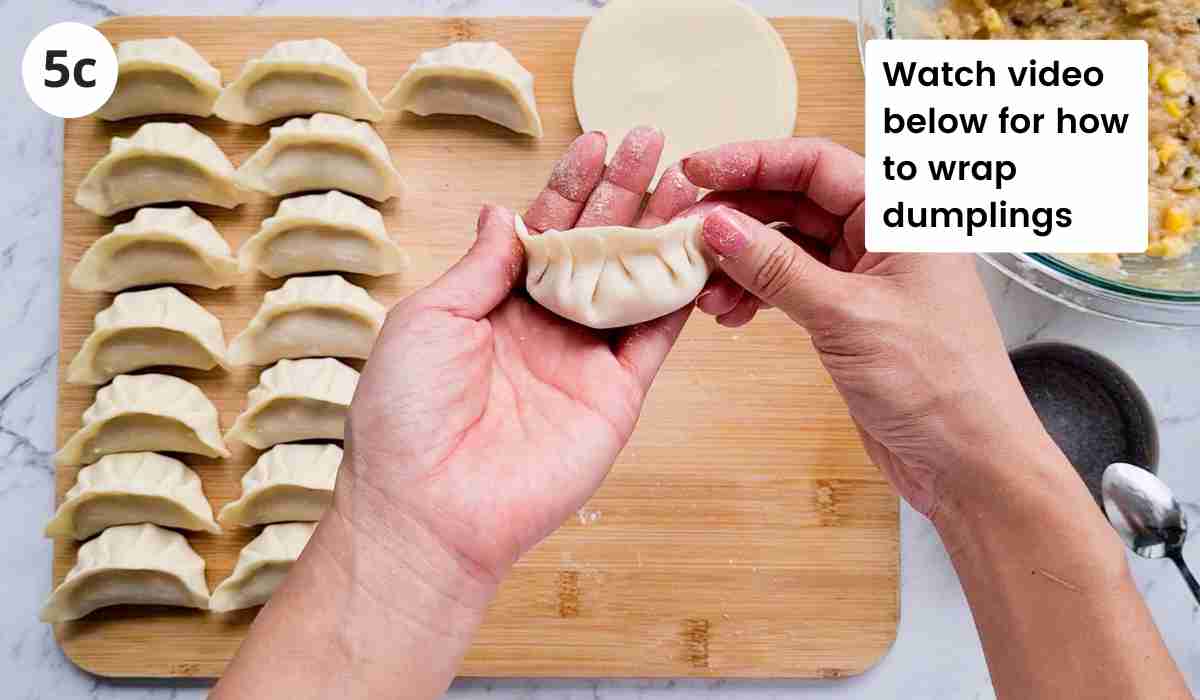 Wrapped dumpling with caption held up by two hands