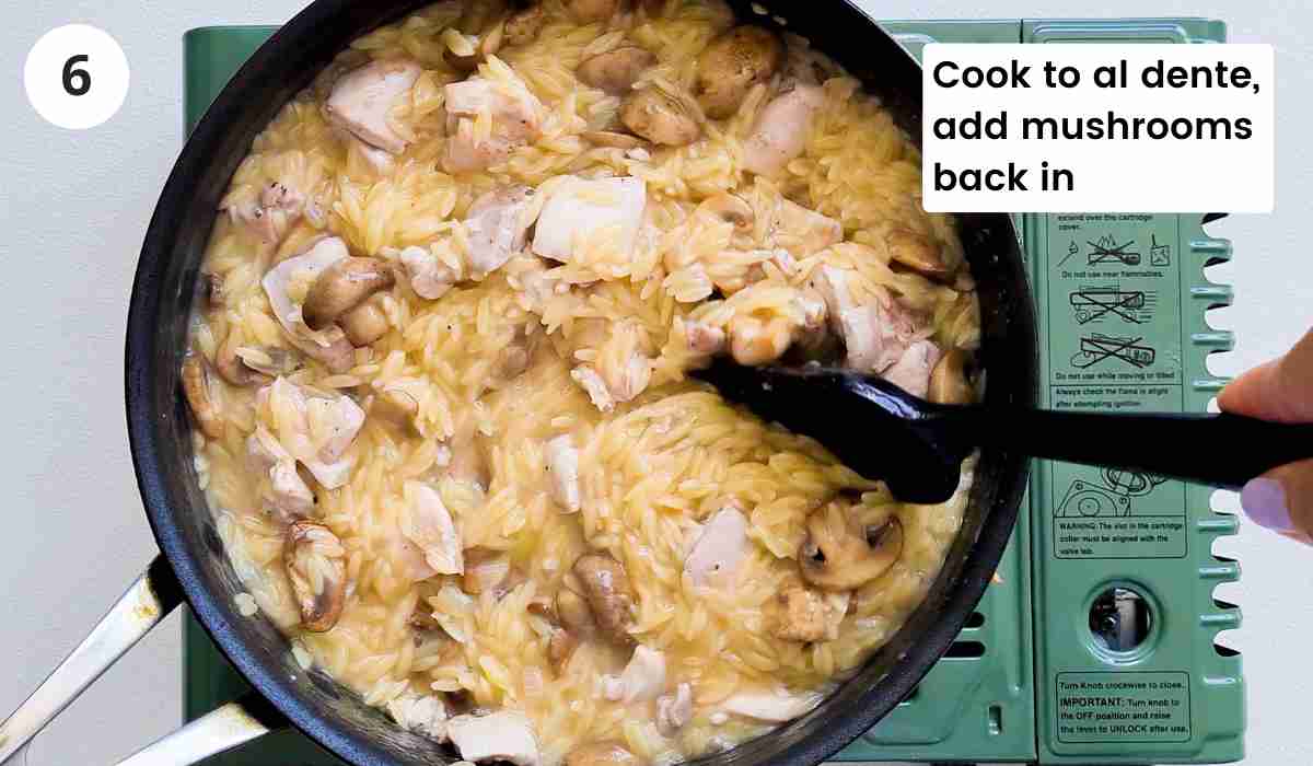 orzo, chicken and mushrooms being stirred in a saute pan